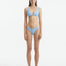  Aeron Baby Blue Bikini Top with scoop neck design, featuring shell-shaped gold button details.