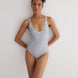 Front "Front view of Agneta Grey/White Reversible Bodysuit showcasing its modern design and moderate coverage." View: Model in Agneta Grey/White Reversible Bodysuit  - MOEVA Luxury Swimwear, 2 in 1 Reversible Bodysuit, UV Protection, Suitable for Swimming, V Neckline, MOEVA Luxury Swimwear