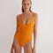 "Model wearing the Agneta Orange/Pink reversible bodysuit from the front, showcasing its modern design with a scoop neckline and body-hugging fit. "