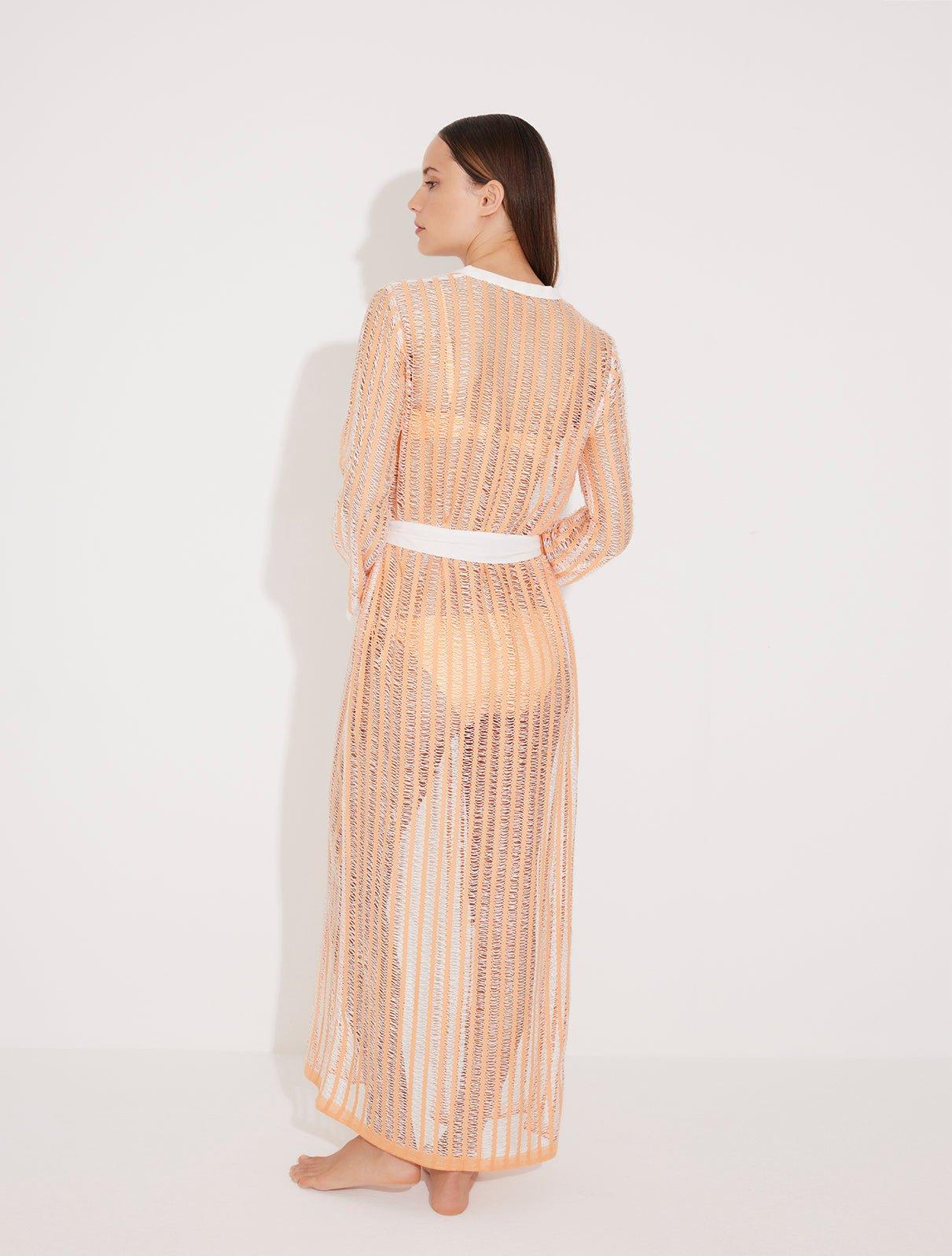 "Back view of the Aitana Orange/White Kaftan, highlighting its ankle-length silhouette, long sleeves, and crisscross knit design. "