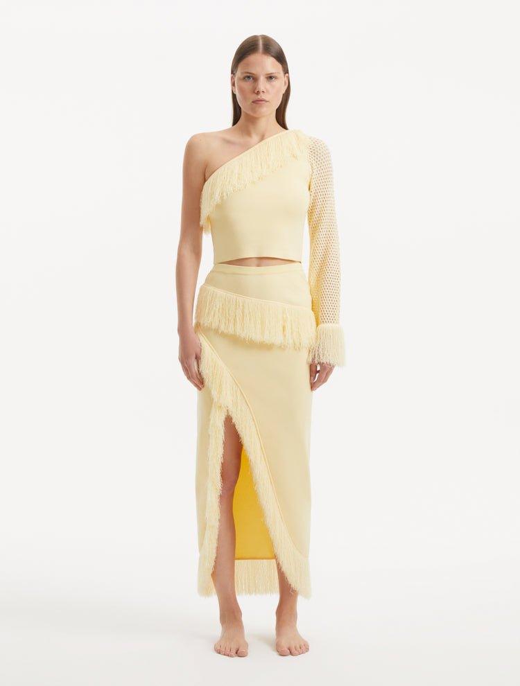 "Model showcasing the Alani Yellow Skirt from the front, highlighting the high-waisted fit, intricate knitwork, and playful fringed hem."