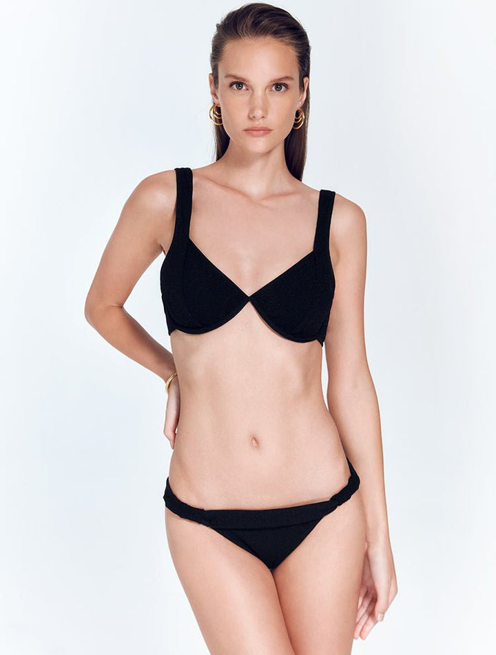 Front View: Model in Alexa Shiny Black Bikini Top - MOEVA Luxury Swimwear, Underwired Top, V Neck, MOEVA Luxury Swimwear