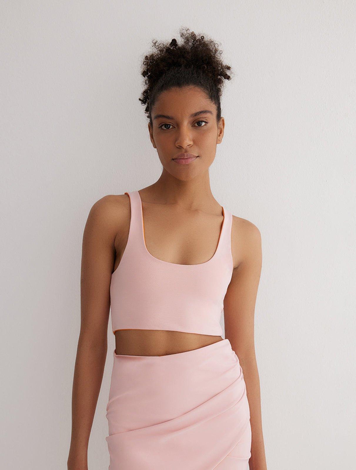 "Front view of a model wearing Alva Orange/Pink Crop Top, showcasing the scoop neckline and sleek fit."