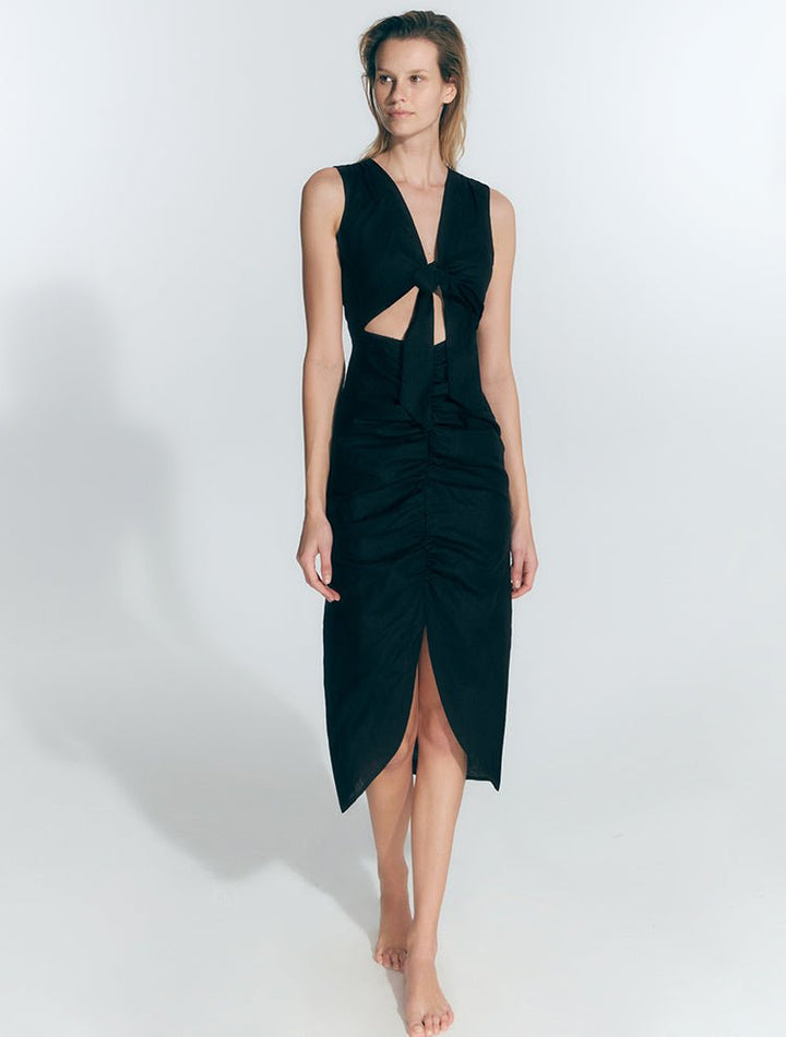 Front View: Model in Amiyah Black Dress - MOEVA Luxury Swimwear, Cutout at Front, Ruched Silhouette, Tie at Front, V Neckline, 100% Polyester, MOEVA Luxury Swimwear