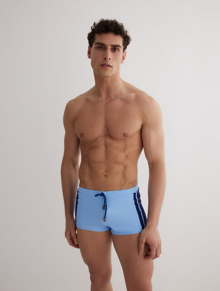 Front View: Model in Antonio Baby Blue/Blue Trunks - MOEVA Luxury Swimwear, Duo/Tri-Colored, Elasticated Waistband, Strechy Fabric, Tie at the Front, Quick Dry, Comfortable Fit, MOEVA Luxury Swimwear
