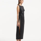 "Side view of the Apollo Black Dress, showcasing the asymmetrical cut and provocative side slit that adds a modern edge."