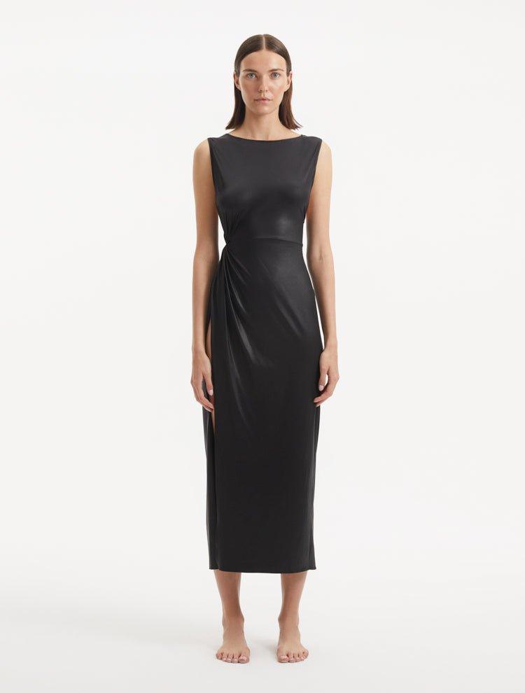 "Model wearing the Apollo Black Dress from the front, highlighting the classic boat neckline, twist knot detail, and luxurious satin fabric."