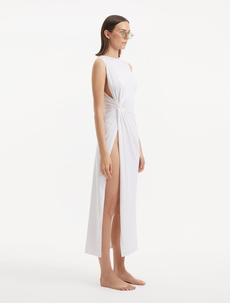 "Side view of the Apollo White Dress, emphasizing the asymmetrical hem and side slit that add a dynamic and daring touch."