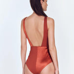 "Back view of the Aria Red Ochre Swimsuit showing the low back and moderate bottom coverage."