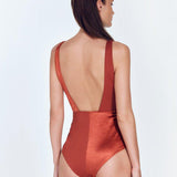 "Back view of the Aria Red Ochre Swimsuit showing the low back and moderate bottom coverage."