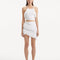 "Model showcasing the Arlo White Skirt from the front, highlighting the hand-knitted texture, high-rise cut, and playful fringed details."