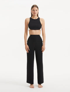 "Model showcasing the Augustine Black White Top and Wade Pants from the front, highlighting the stylish cropped cut and one-shoulder design."