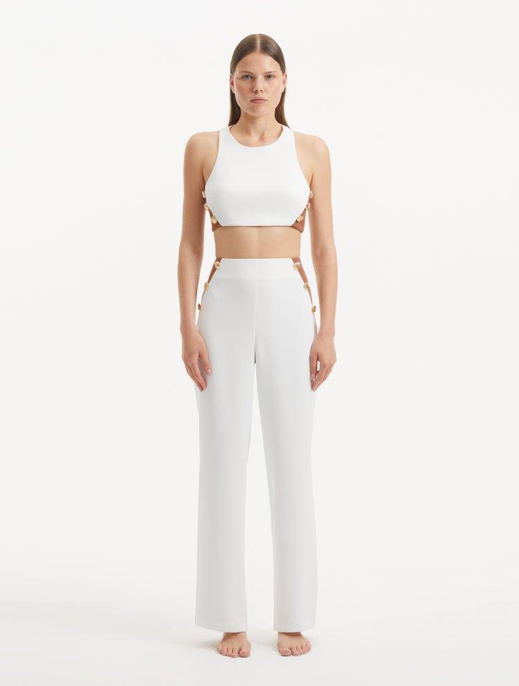 "Model showcasing the Augustine White/Brown Pants from the front, highlighting the trendy cropped silhouette and unique one-shoulder design."