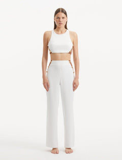 "Model showcasing the Augustine White Brown Top and Wade Pants from the front, highlighting the trendy cropped silhouette and unique one-shoulder design."