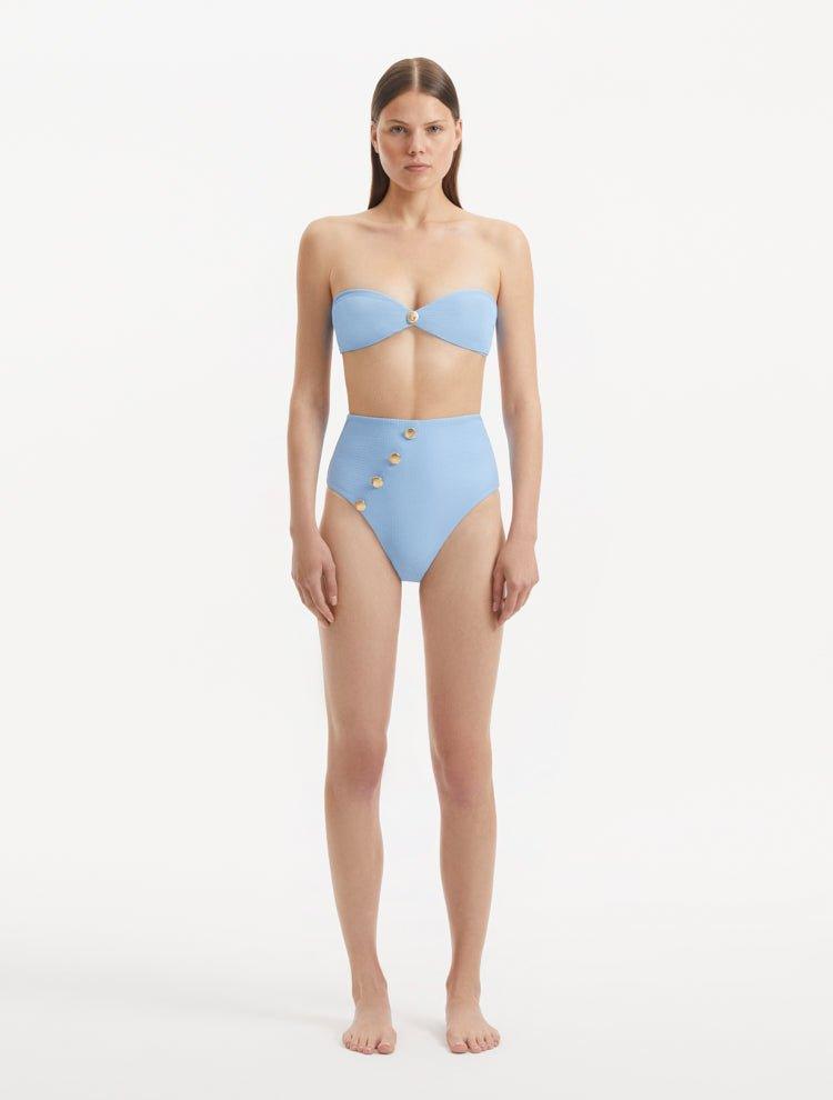 "Front view of Baia baby blue high-waist bikini bottom featuring shell-shaped gold buttons and luxurious Italian fabric."