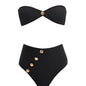 Model showcasing the Baia Black Bikini Set from the front, highlighting the strapless bandeau top with gold shell buttons and the sleek, minimalist bikini bottom with gold detailing.