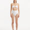 Front view of Baia White Bikini Top, showcasing bandeau design and shell-shaped gold buttons.