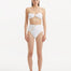 Front view of Baia White Bikini Top, showcasing bandeau design and shell-shaped gold buttons.