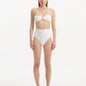 Front view of Baia White Bikini Top, showcasing bandeau design and shell-shaped gold buttons.