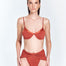 "Front view of model wearing Beatrice Red Ochre Bikini Top – underwire and gold clasps visible."