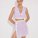 "Model wearing Blanca Lilac/White Asymmetrical Dress with gold button accents."