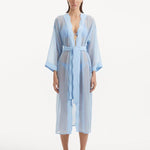 Model wearing the Blaze baby blue kaftan from the front, highlighting its V neckline, wavy design details, and ankle-length flow. The self-tie belt accentuates the waistline, offering a chic and adjustable fit.