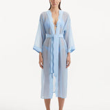 Model wearing the Blaze baby blue kaftan from the front, highlighting its V neckline, wavy design details, and ankle-length flow. The self-tie belt accentuates the waistline, offering a chic and adjustable fit.