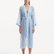 Model wearing the Blaze baby blue kaftan from the front, highlighting its V neckline, wavy design details, and ankle-length flow. The self-tie belt accentuates the waistline, offering a chic and adjustable fit.