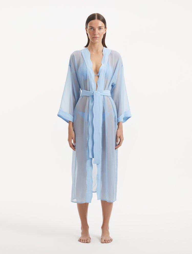 Model wearing the Blaze baby blue kaftan from the front, highlighting its V neckline, wavy design details, and ankle-length flow. The self-tie belt accentuates the waistline, offering a chic and adjustable fit.