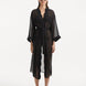 Model showcasing the Blaze black kaftan from the front, emphasizing its V neckline, wavy design details, and ankle-length flow. The self-tie belt highlights the waistline, offering a flattering and adjustable fit.