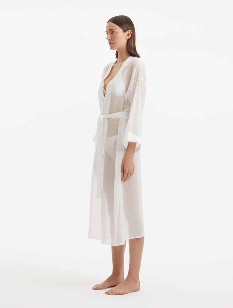 "Side view of the Blaze white kaftan, featuring its transparent fabric and wavy details that bring a touch of feminine whimsy to the overall design."