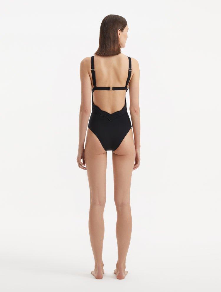 Back view of Breena Black Swimsuit, highlighting low-back cut and gold clasp accents.