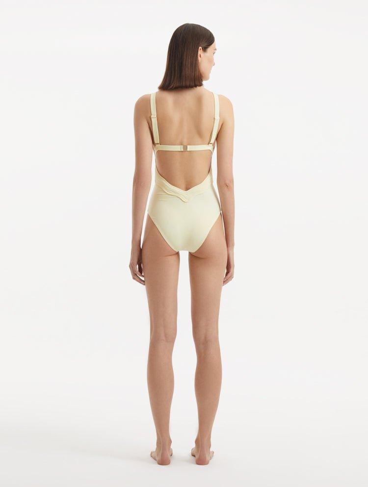 Back view of Breena Yellow Swimsuit, featuring low-back cut and gleaming gold clasps.