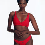 "Front view of the Brenda Bikini Top with chic crossover design and button details on a model."