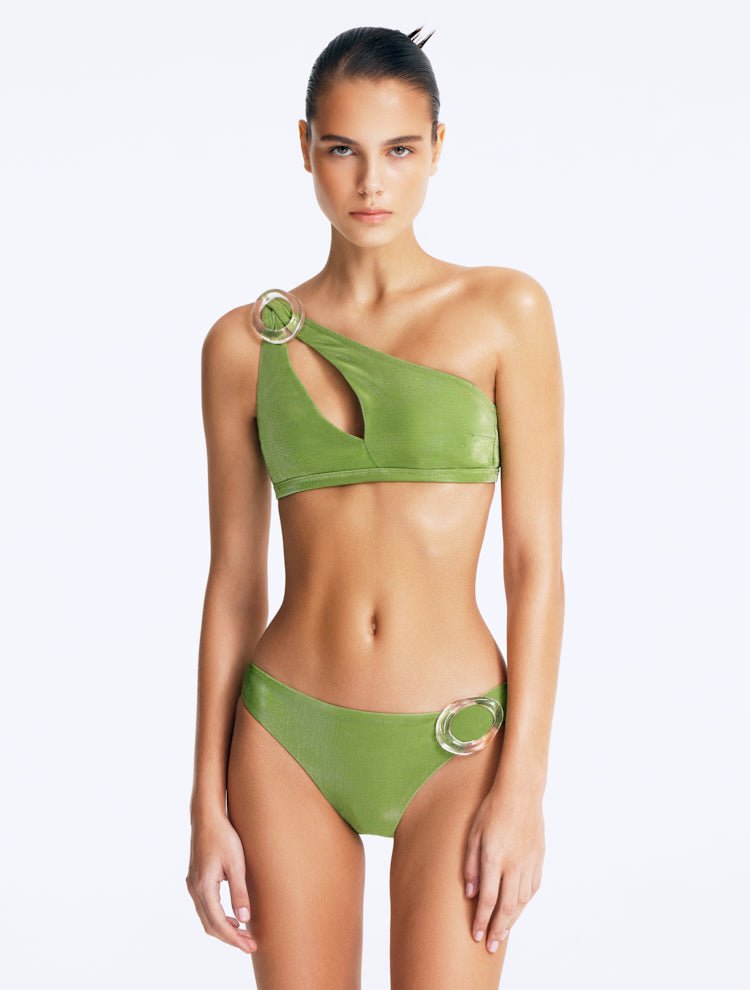 Front View: Model in Calix Green Bikini Top - One Shoulder, Metallic Fabric, Clear Glass Hoop Accessory, Slash Cut Out, Gold Clasps, MOEVA Luxury Swimwear