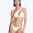 "Model wearing the Carol Seersucker White Bikini Bottom from the front. The bottom features a low-rise silhouette with small coverage and thin elasticated straps."