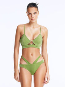 Front View: Model in Cassia Green Bikini Top - Scoop Neck, Metallic Fabric, Clear Glass Drop Shaped Accessory, Topstitching Details, Gold Clasps, MOEVA Luxury Swimwear