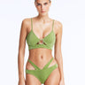 Front View: Model in Cassia Green Bikini Top - Scoop Neck, Metallic Fabric, Clear Glass Drop Shaped Accessory, Topstitching Details, Gold Clasps, MOEVA Luxury Swimwear