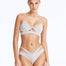 Front View: Model in Cassia Silver Bikini Top - Scoop Neck, Metallic Fabric, Clear Glass Drop Shaped Accessory, Topstitching Details, Gold Clasps, MOEVA Luxury Swimwear