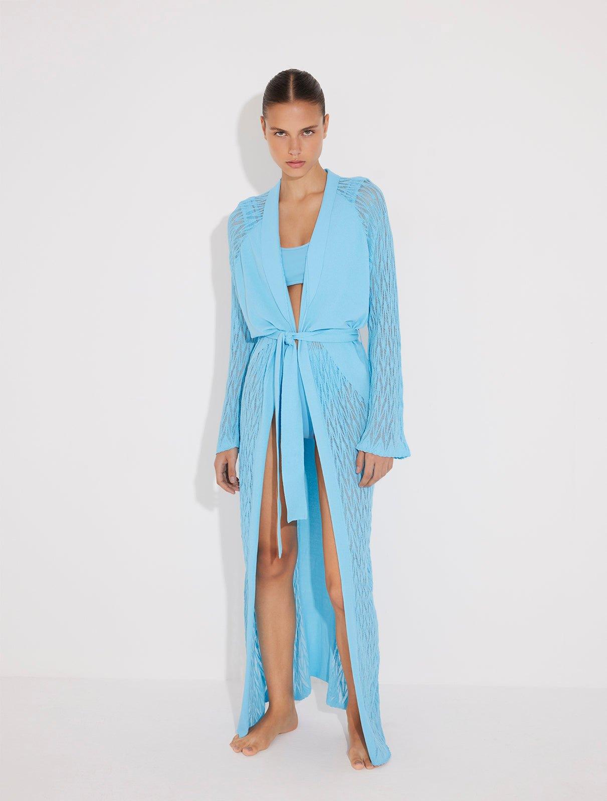 "Front view of a model in the Chad Blue Kaftan, displaying the layered neckline and mesh panels."