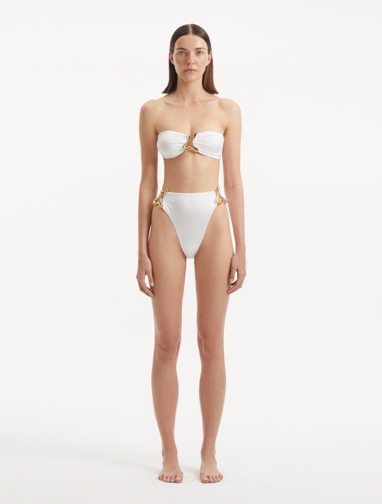 Front view of the Clyde White Bikini Bottom highlighting the high-waist design and gold sculpted accessories.