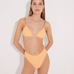 "Model wearing the Como Orange High-Waisted Bikini Bottom from the front, highlighting its high-leg cut, topstitching details, and full bottom coverage."