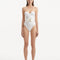 Model wearing the Coral White Swimsuit, showcasing the balconette style and gold-shaped accessory details.