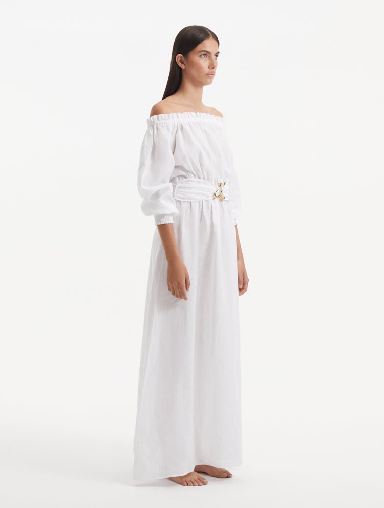 "Side view of the Dante White Dress, showcasing the long puffed sleeves and the flowing, ankle-length silhouette."