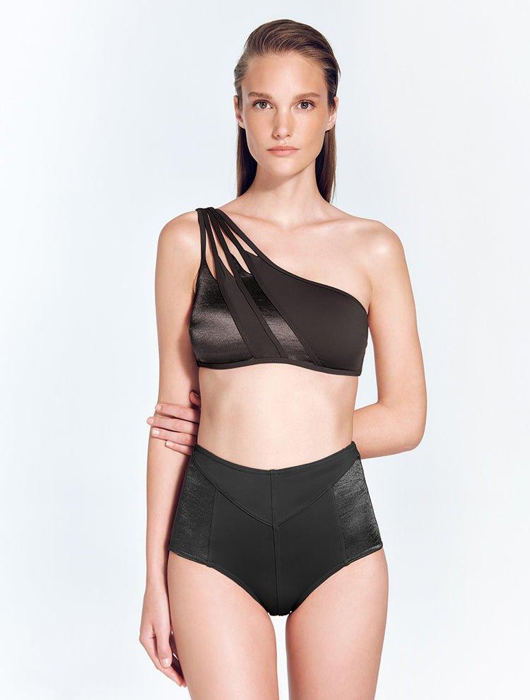 "Front view of the Darika Black Bikini Top, showing the geometric one-shoulder design and cutout details."