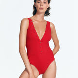 "Darla Red Swimsuit front view featuring a plunge neck, side pockets, and button detailing along the V neckline."