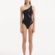 Model wearing the Delta Black Swimsuit, highlighting the one-shoulder design and asymmetric cutouts.