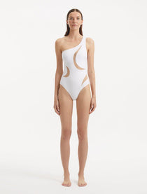 Model showcasing the Delta White Swimsuit, highlighting the one-shoulder design and asymmetric cutouts.