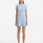 "Model wearing the Derin Baby Blue Dress from the front, showcasing the knee-length cut and shell-shaped gold buttons."