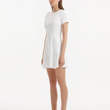 "Side view of the Derin White Dress, highlighting the flared hem and elegant silhouette."